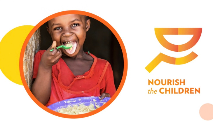 Uśmiechnięta dziewczynka jedząca posiłek z talerza.