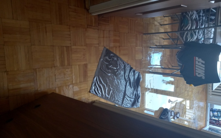 Zalany podłoga w pomieszczeniu, widoczna kałuża.