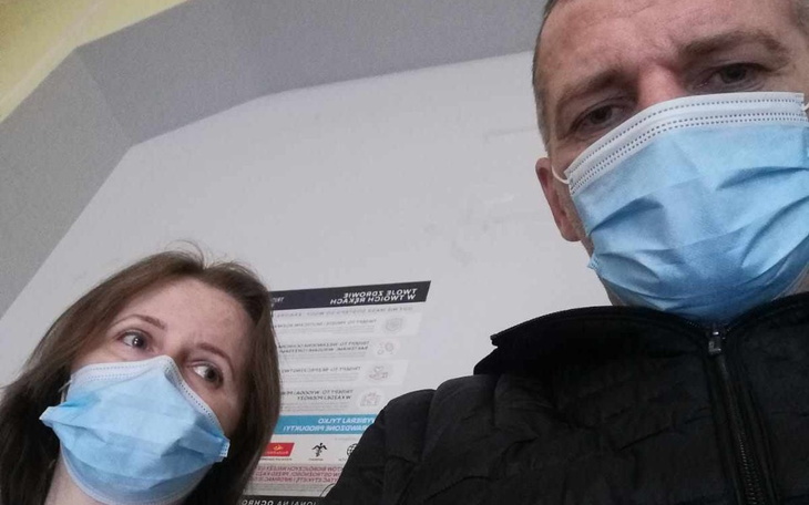 Dwoje ludzi w maseczkach, patrzących w stronę kamery.