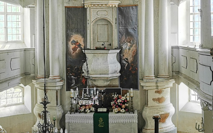 Wnętrze kościoła z dekoracjami i kwiatami.