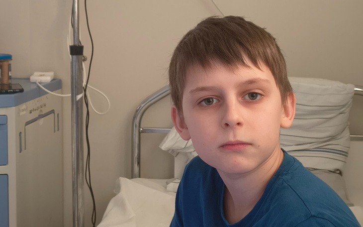 Chłopiec w szpitalu, z poważnym wyrazem twarzy.