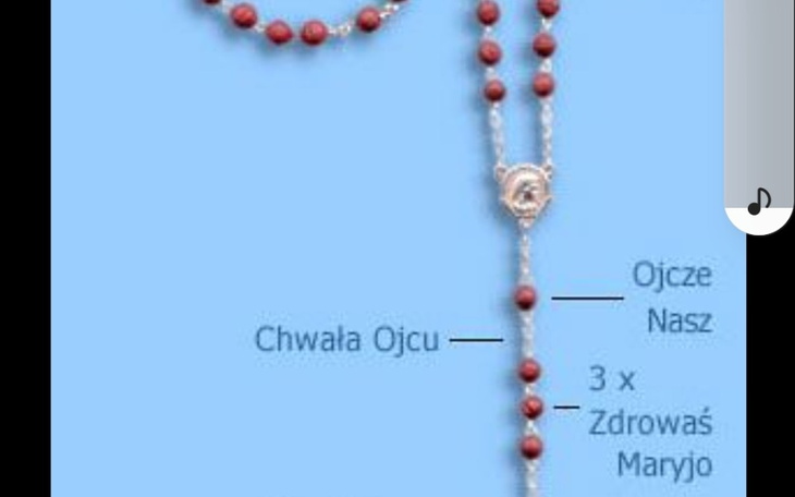 Różaniec z czerwonymi koralikami, z opisem modlitw.