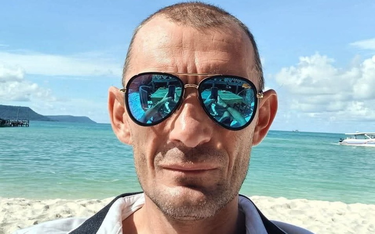 Mężczyzna w okularach przeciwsłonecznych na plaży.