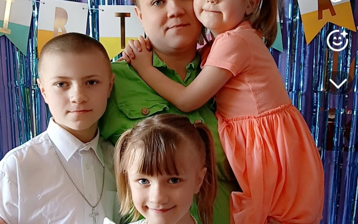 Rodzina z dziećmi na przyjęciu urodzinowym, uśmiechnięci.