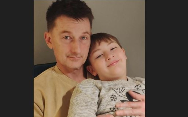 Mężczyzna z dzieckiem, obaj uśmiechnięci i zrelaksowani.