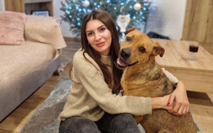 Kobieta przytulająca psa w przytulnym wnętrzu.