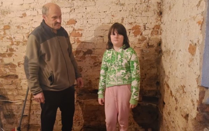 Dwoje ludzi w opuszczonym pomieszczeniu, z poważnymi minami.