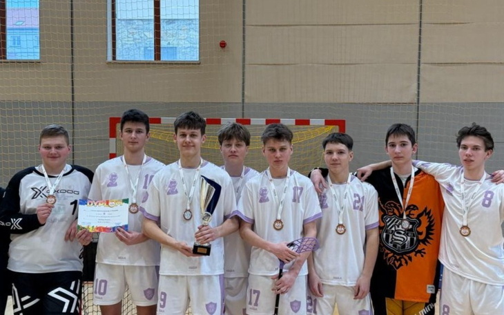 Zespół młodych sportowców z pucharem i medalami po zwycięstwie.