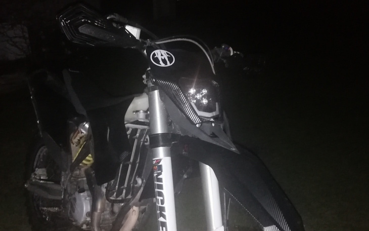 Motocykl w nocy, z widocznymi detalami i oświetleniem.