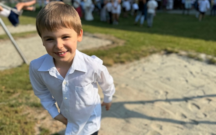 Uśmiechnięty chłopiec bawiący się na placu zabaw.