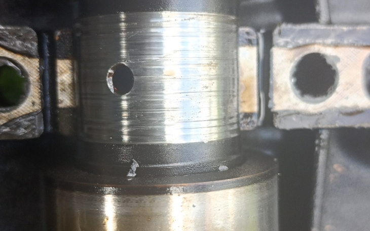 Zbliżenie na metalowy element z widocznymi rysami.