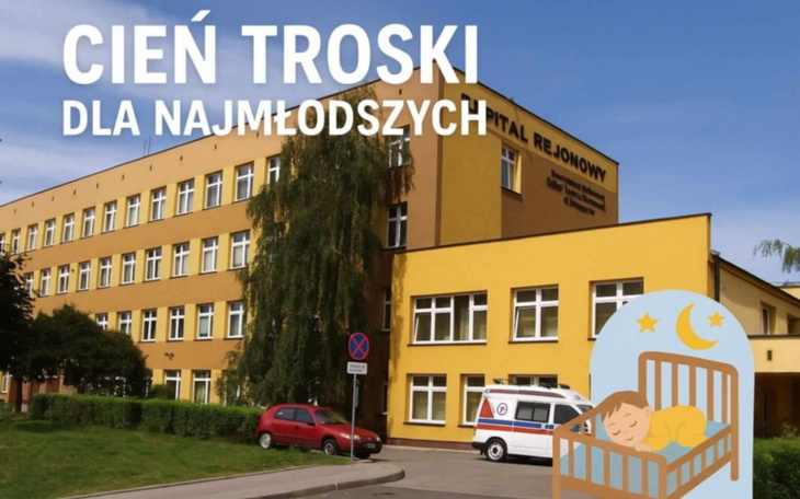 Budynek szpitala z napisem 'Cień Troski dla Najmłodszych'.
