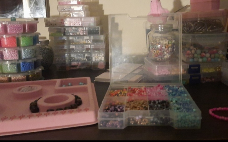 Stół z różnorodnymi koralikami i materiałami do rękodzieła.