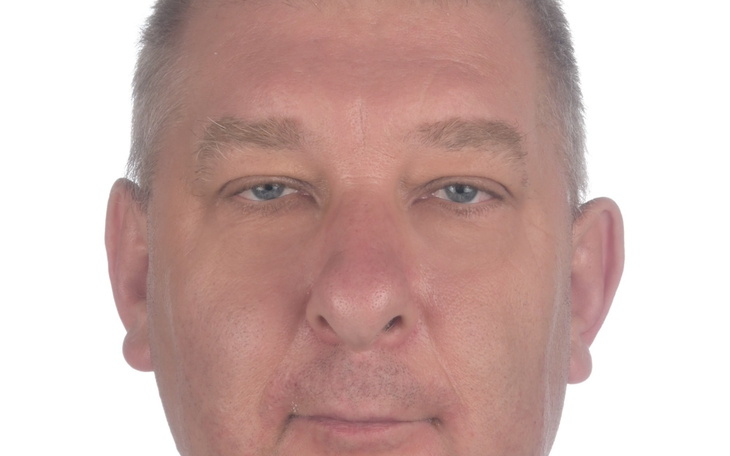 Mężczyzna z poważnym wyrazem twarzy, patrzący w obiektyw.