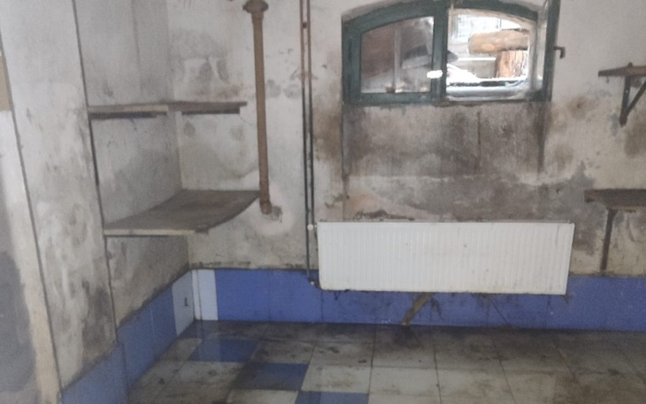 Zniszczona, brudna piwnica z wilgocią.