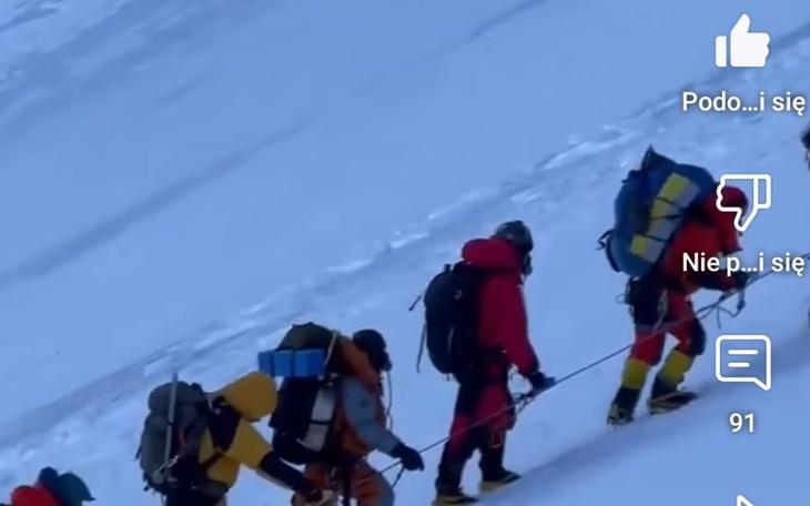 Grupa wspinaczy na stoku górskim w trudnych warunkach.