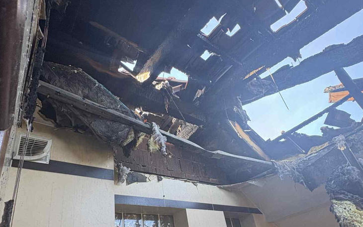 Zniszczony dach po pożarze, widoczne uszkodzenia i wypalone elementy.