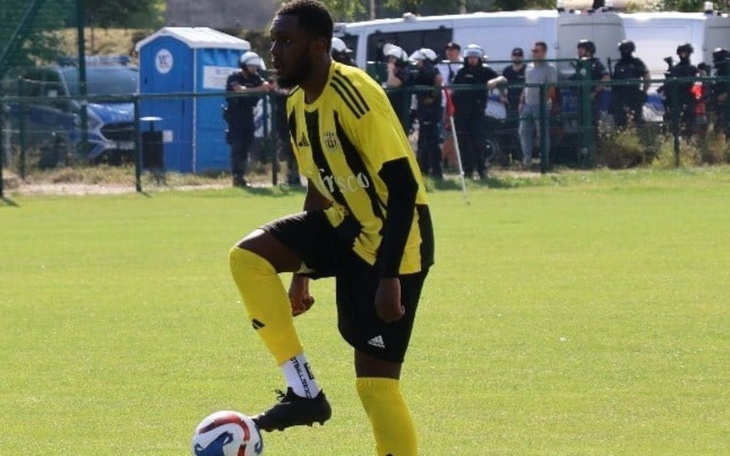 Piłkarz w żółto-czarnym stroju, przygotowujący się do gry na boisku.