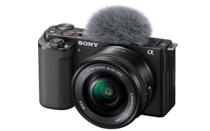 Aparat fotograficzny z futerkiem na obiektywie.