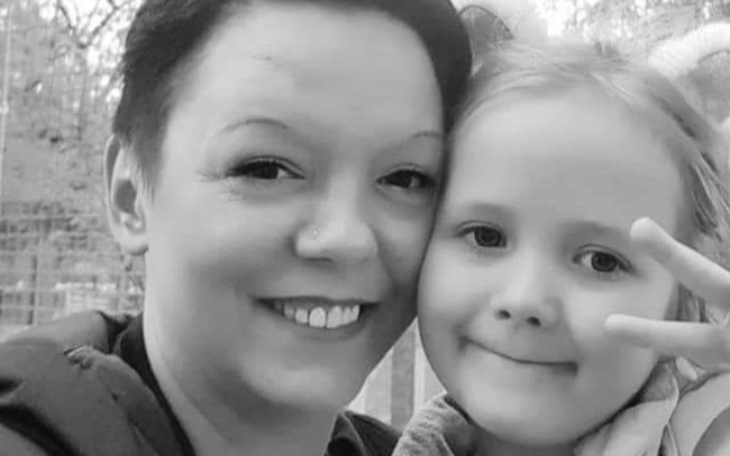 Czarno-białe zdjęcie matki z córką, uśmiechające się do kamery.