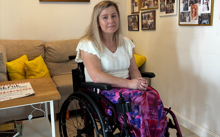 Kobieta na wózku inwalidzkim w przytulnym wnętrzu.