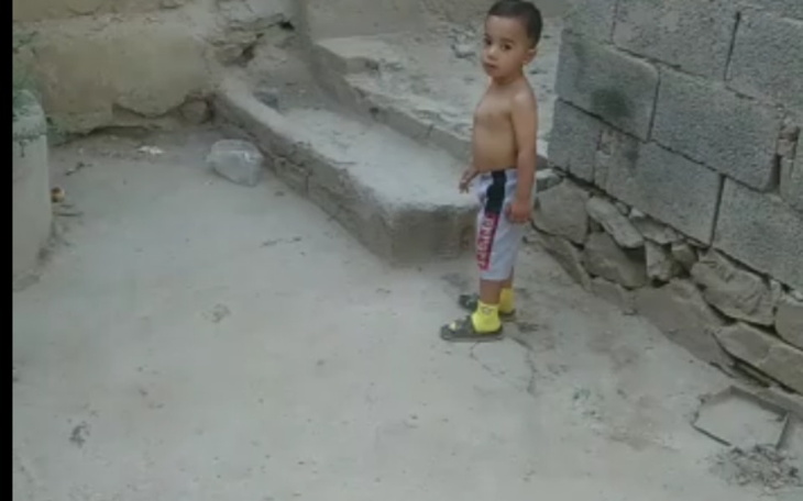 Mały chłopiec bawiący się na podwórku.