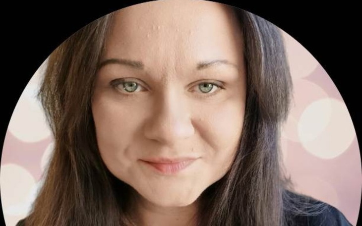 Kobieta z uśmiechem na twarzy, patrząca w obiektyw.