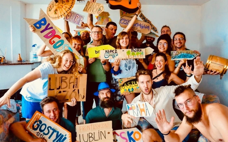 Grupa ludzi z tabliczkami w radosnej atmosferze.