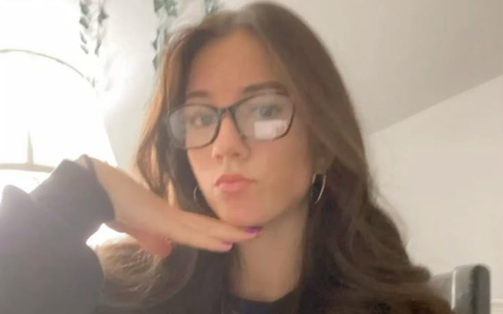 Młoda kobieta w okularach, pozująca do zdjęcia.