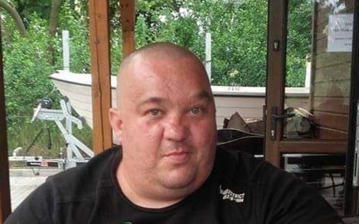 Mężczyzna z krótkimi włosami, siedzący przy stole.