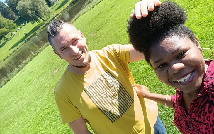 Para przyjaciół na zielonej łące, ciesząca się wspólnym czasem.