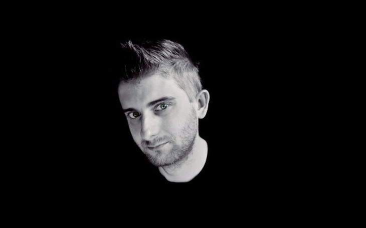 Portret mężczyzny na czarnym tle, z wyrazistymi oczami.