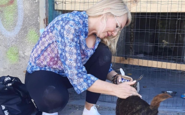 Kobieta głaszcząca psa w schronisku, pełna empatii i miłości.