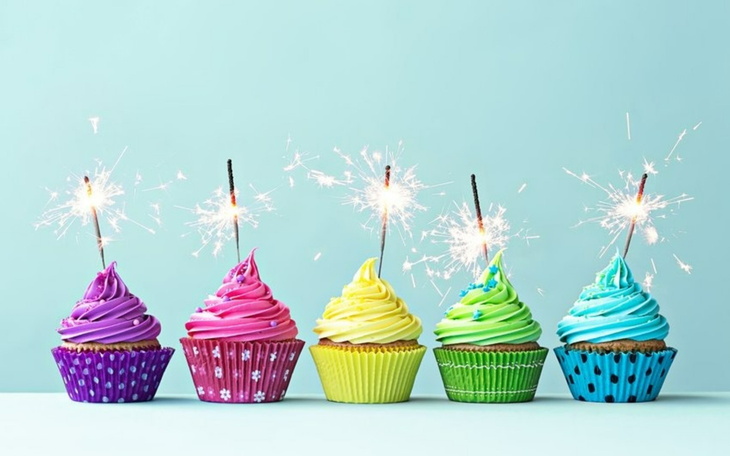 Kolorowe babeczki z iskrami na jasnym tle.