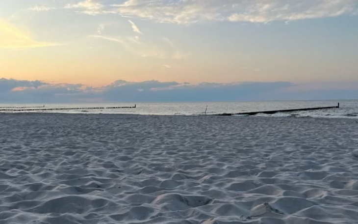 Widok na plażę o zachodzie słońca.