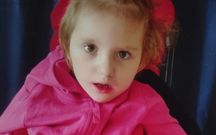 Dziewczynka w wózku, z uśmiechem, na spacerze.