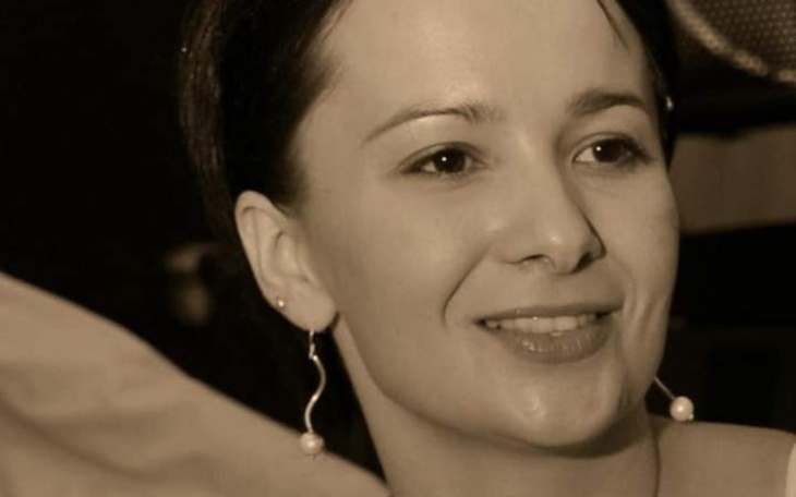 Portret kobiety w sepia, uśmiechającej się.