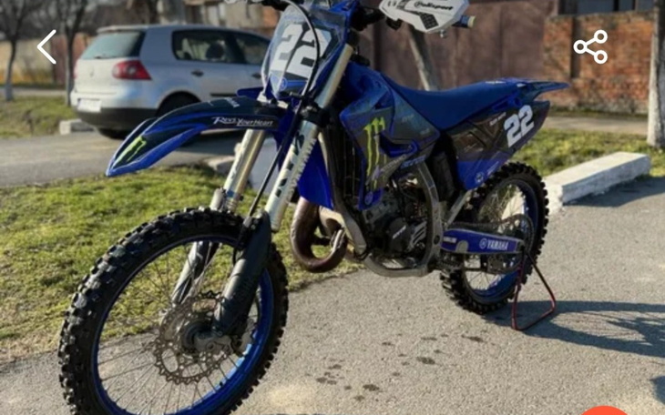 Motocykl terenowy w niebieskim kolorze, gotowy do jazdy.