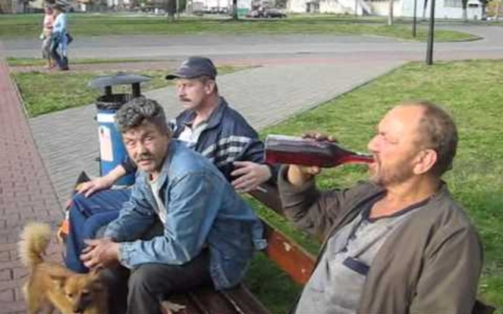 Trzech mężczyzn siedzących na ławce w parku.