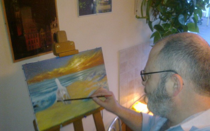 Artysta malujący pejzaż nadmorski w przytulnym wnętrzu.