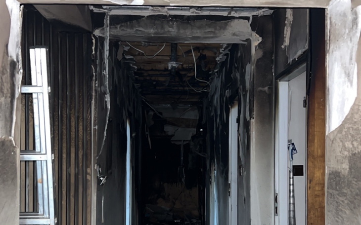 Zniszczony korytarz z widocznymi śladami po pożarze.