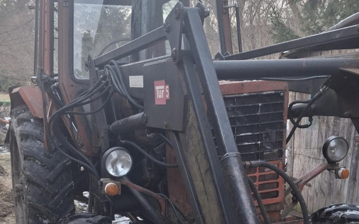 Stary traktor, widok z przodu, z widocznymi detalami.