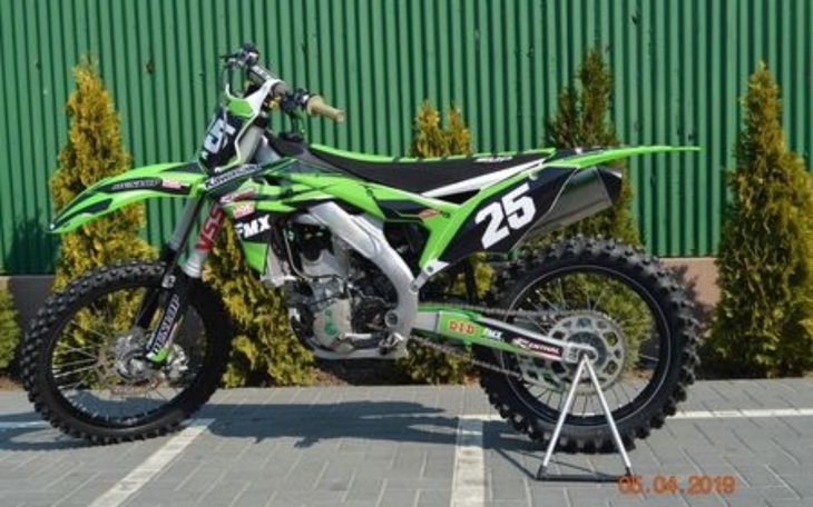 Motocykl crossowy w zielono-czarnym kolorze, gotowy do jazdy.