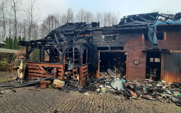 Zniszczony dom po pożarze, z widocznymi zniszczeniami.