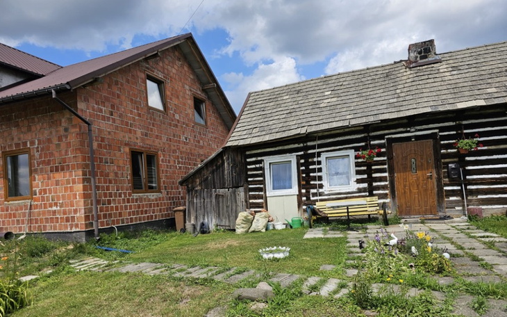 Widok na dwa różne domy, jeden nowoczesny, drugi tradycyjny.