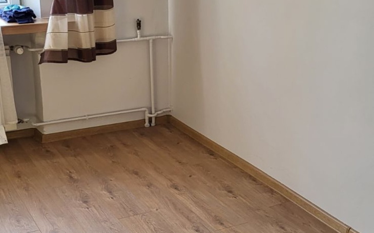 Pusty pokój z drewnianą podłogą i oknem.