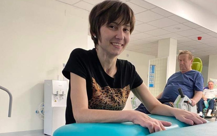 Kobieta uśmiechająca się podczas rehabilitacji w szpitalu.