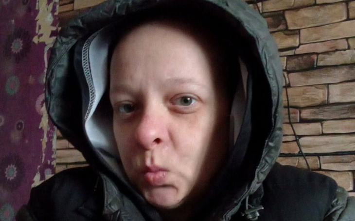 Kobieta w kapturze z wyrazem twarzy.