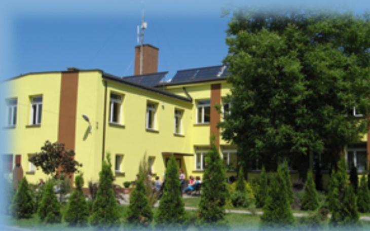 Kolorowy budynek z zielonymi drzewami w tle.