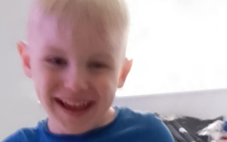 Uśmiechnięty chłopiec w niebieskiej koszulce.